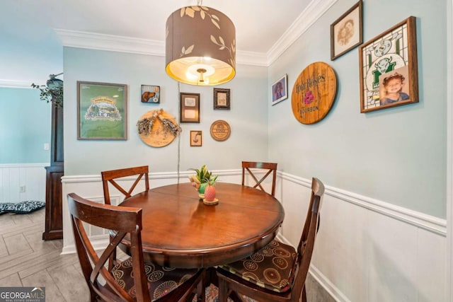 dining area featuring crown molding and wainscoting
