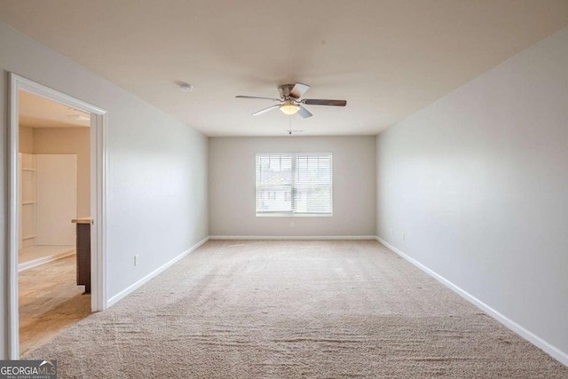 empty room with carpet floors, ceiling fan, and baseboards