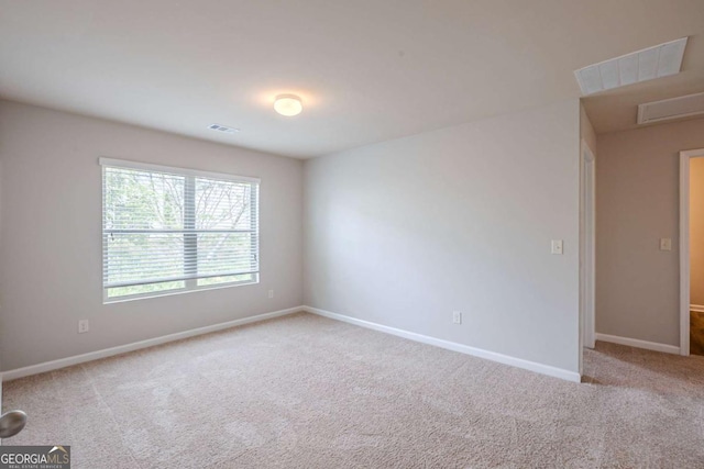 spare room featuring baseboards, carpet flooring, and visible vents
