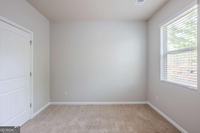carpeted empty room with baseboards and visible vents