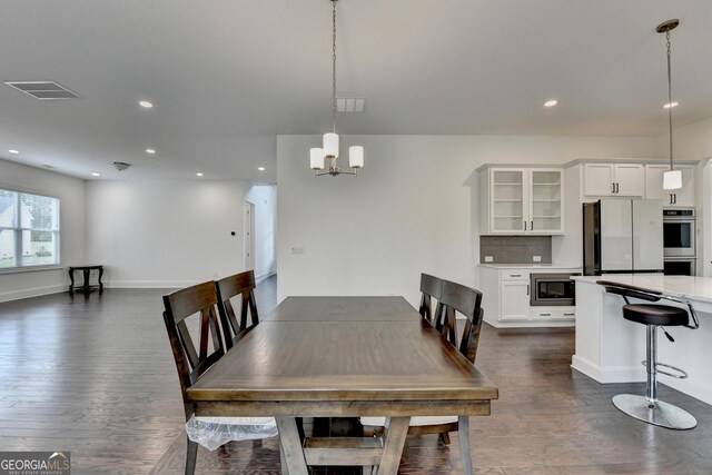 dining space with visible vents, recessed lighting, dark wood finished floors, and a chandelier