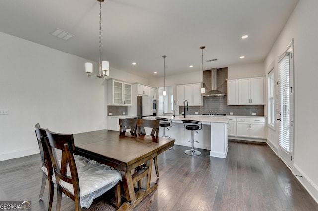 dining room featuring visible vents, dark wood-style flooring, baseboards, and a notable chandelier