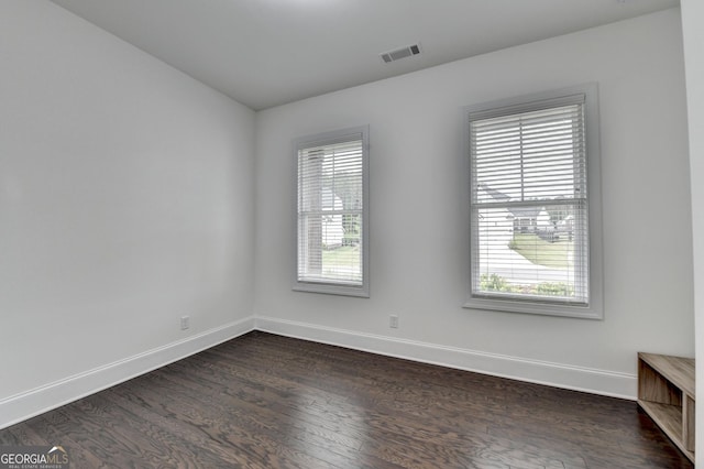 spare room with baseboards, a wealth of natural light, and visible vents