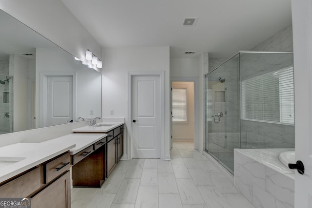 full bath featuring double vanity, a shower stall, a sink, and marble finish floor