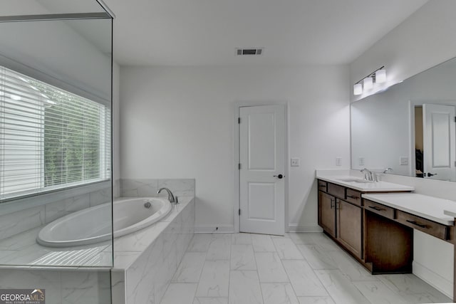 bathroom featuring visible vents, a garden tub, marble finish floor, vanity, and baseboards