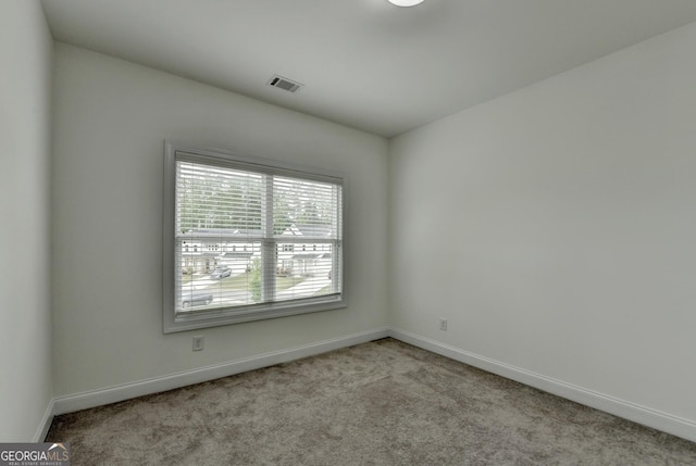 carpeted spare room with baseboards and visible vents