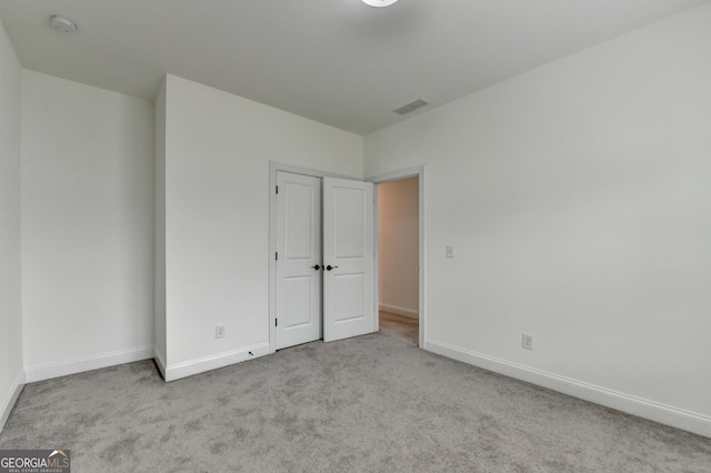 unfurnished bedroom with baseboards, visible vents, and carpet