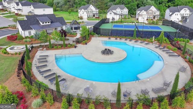 community pool featuring fence and a residential view