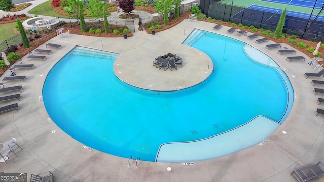 community pool featuring fence and a patio