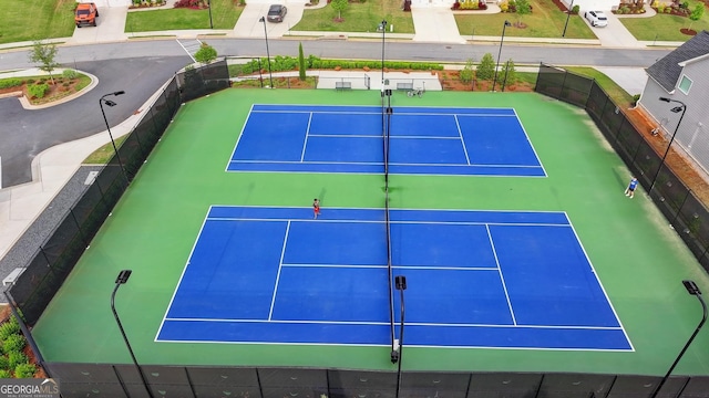 view of tennis court featuring fence