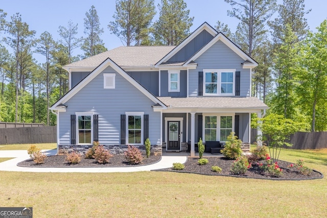 craftsman inspired home featuring fence, a shingled roof, a front lawn, board and batten siding, and a porch