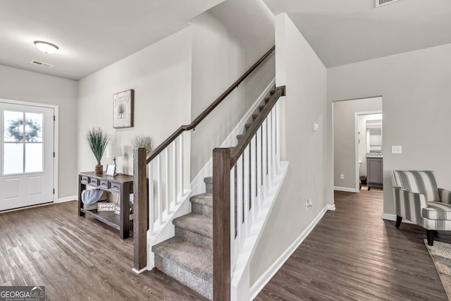 foyer entrance featuring visible vents, stairs, baseboards, and dark wood-style floors
