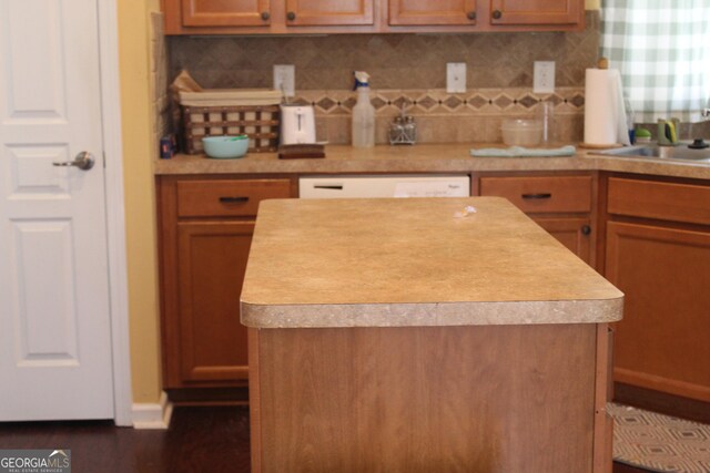 121 Plumleaf Ct, Griffin, GA 30223 - kitchen featuring white dishwasher, a center island, a sink, backsplash, and light countertops