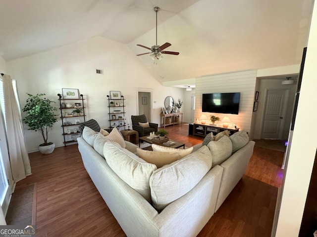 living area with ceiling fan, dark wood finished floors, high vaulted ceiling, and baseboards