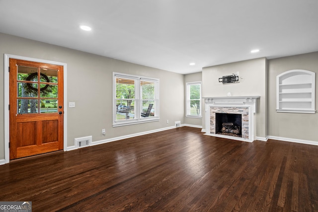 unfurnished living room featuring visible vents, recessed lighting, dark wood finished floors, and a wealth of natural light