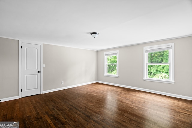 spare room featuring baseboards and wood finished floors