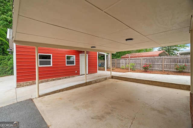 view of patio featuring fence and a carport