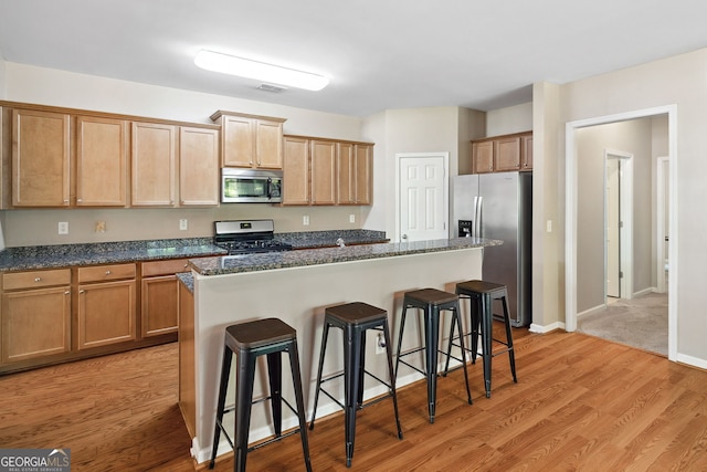 1355 Hesse Ln, Austell, GA 30106 - kitchen with a kitchen bar, visible vents, a center island, light wood-type flooring, and stainless steel appliances