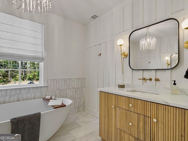 650 Jones Rd, Roswell, GA 30075 - full bathroom with a notable chandelier, vanity, marble finish floor, visible vents, and a soaking tub