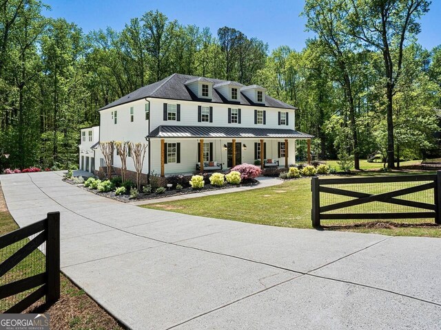 650 Jones Rd, Roswell, GA 30075 - view of front of home featuring fence, a porch, a front yard, concrete driveway, and a standing seam roof