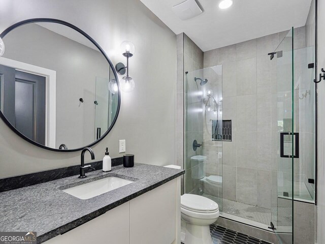 650 Jones Rd, Roswell, GA 30075 - full bathroom with vanity, toilet, tile patterned floors, and a stall shower