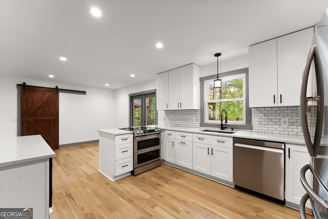 364 Cherokee Trce, Dahlonega, GA 30533 - kitchen featuring white cabinets, a sink, stainless steel appliances, a peninsula, and backsplash