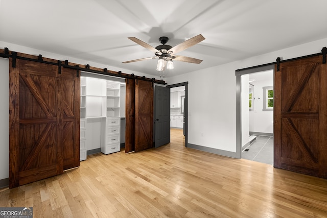 364 Cherokee Trce, Dahlonega, GA 30533 - unfurnished bedroom with baseboards, a barn door, light wood finished floors, and ensuite bath