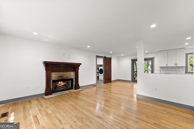 364 Cherokee Trce, Dahlonega, GA 30533 - unfurnished living room featuring washer / clothes dryer, recessed lighting, a barn door, light wood-style flooring, and a wealth of natural light