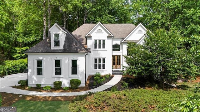view of front of house with a shingled roof and stucco siding