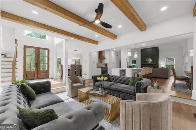living area with beam ceiling, ceiling fan with notable chandelier, wine cooler, recessed lighting, and light wood-style flooring