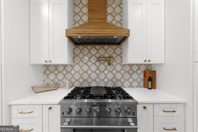 kitchen featuring light countertops, white cabinetry, tasteful backsplash, custom range hood, and high end stainless steel range oven