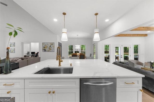 kitchen featuring stainless steel dishwasher, open floor plan, recessed lighting, white cabinetry, and a sink