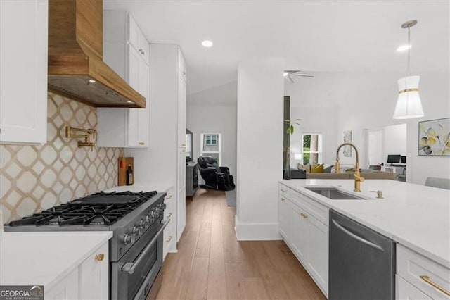 kitchen featuring a sink, light countertops, stainless steel appliances, open floor plan, and custom exhaust hood