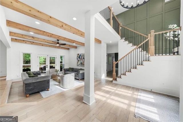 living room with beam ceiling, wood finished floors, baseboards, stairway, and recessed lighting