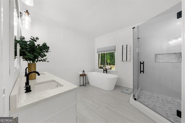 bathroom with a sink, a soaking tub, ornamental molding, and a shower stall