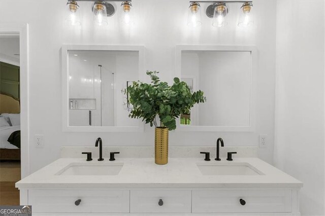 bathroom featuring double vanity, a sink, and ensuite bath