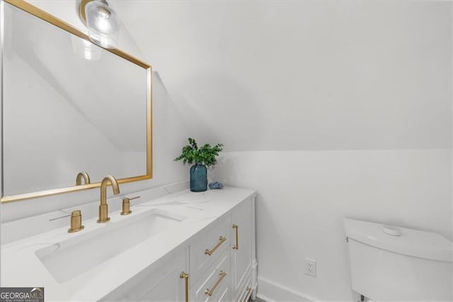 bathroom with vanity, lofted ceiling, and toilet
