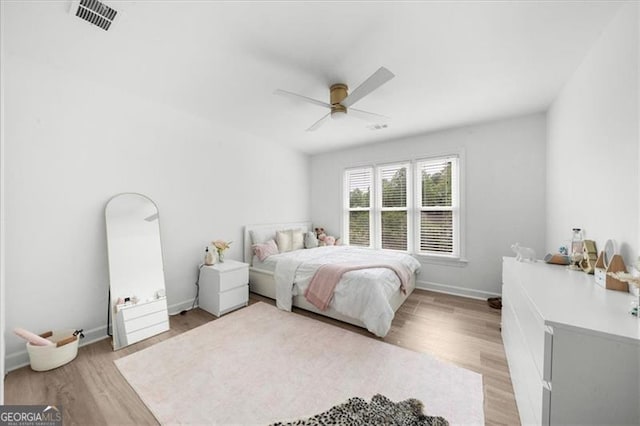bedroom featuring baseboards, visible vents, ceiling fan, and light wood-type flooring