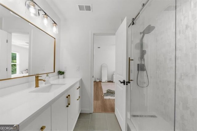 ensuite bathroom with visible vents, ensuite bathroom, a stall shower, and vanity