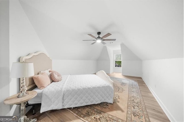 bedroom featuring baseboards, vaulted ceiling, ceiling fan, and light wood-style floors