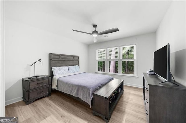 bedroom with baseboards, visible vents, ceiling fan, and light wood finished floors