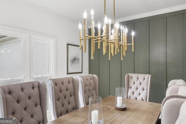 dining area featuring ornamental molding, a decorative wall, and a chandelier