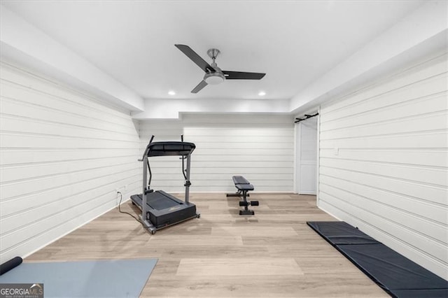 workout area with wooden walls, recessed lighting, ceiling fan, and wood finished floors