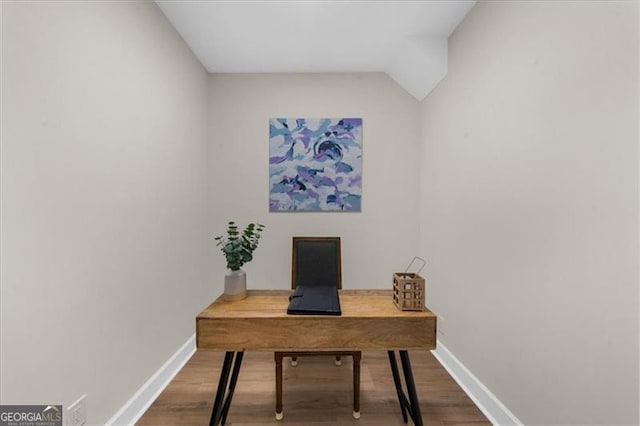 office area with baseboards, vaulted ceiling, and wood finished floors