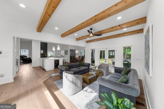 living room featuring french doors, recessed lighting, a healthy amount of sunlight, and beverage cooler