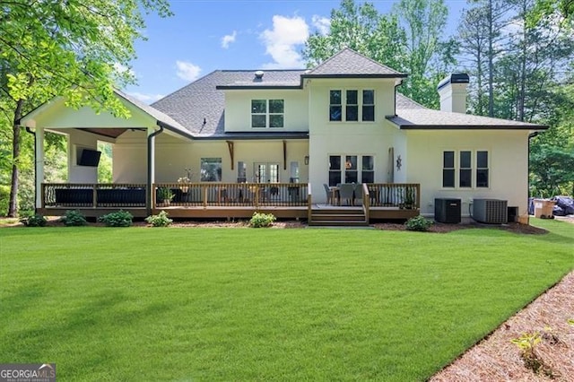 back of house with central AC unit, a wooden deck, a yard, and a chimney
