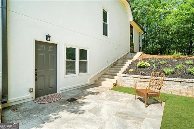 view of home's exterior featuring stairs, stucco siding, and a patio area