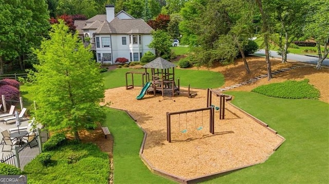 community jungle gym with fence and a yard