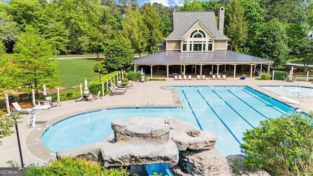 pool featuring fence and a patio area