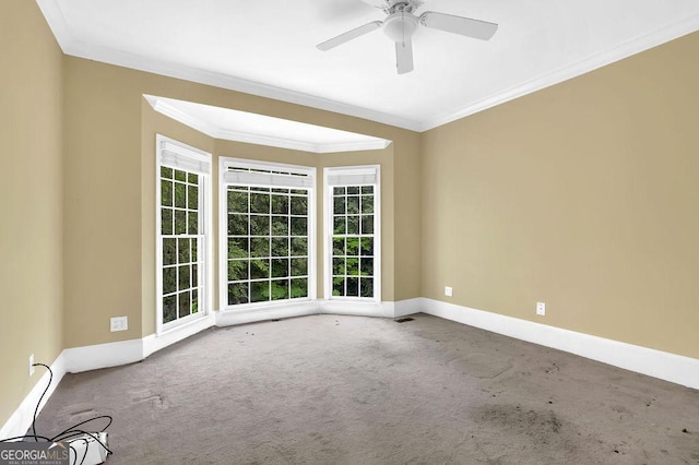 carpeted empty room with crown molding, healthy amount of natural light, baseboards, and ceiling fan